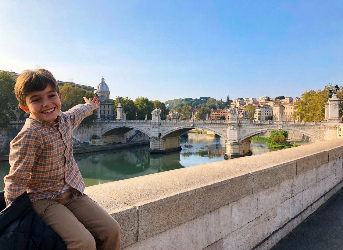 Private driver tour in Rome - happy child enjoying panoramic view of Tiber River and Ponte Vittorio Emanuele II - Edy Car Rome chauffeur service